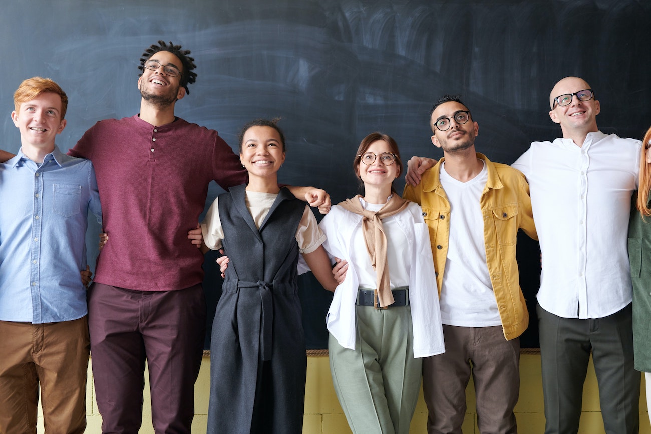 employees standing with arms around each other