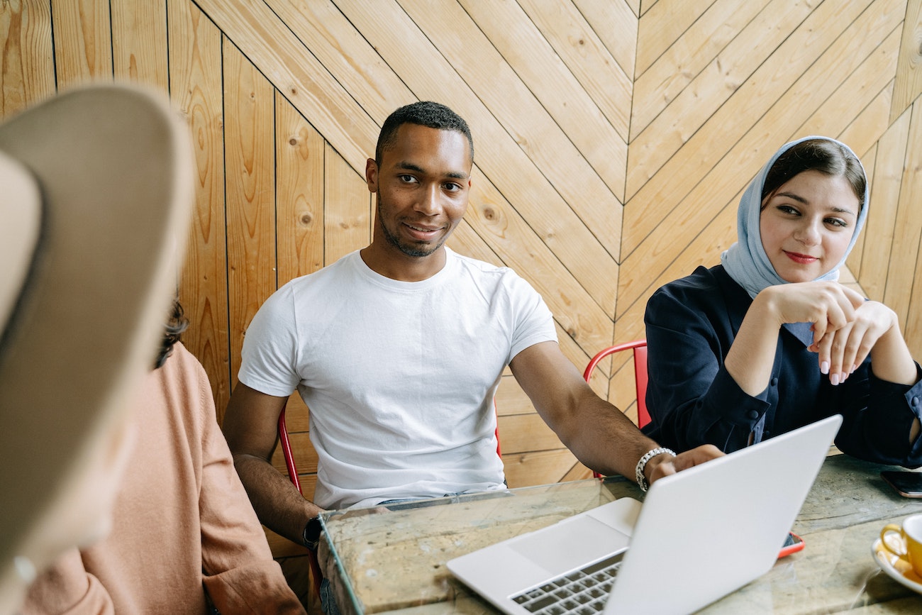 employees talking and working at laptop